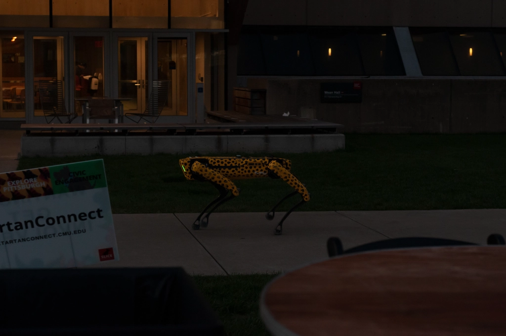 Late evening on CMU campus outside of Wean hall. A spotted Boston Dynamics "Spot" robot is outside.