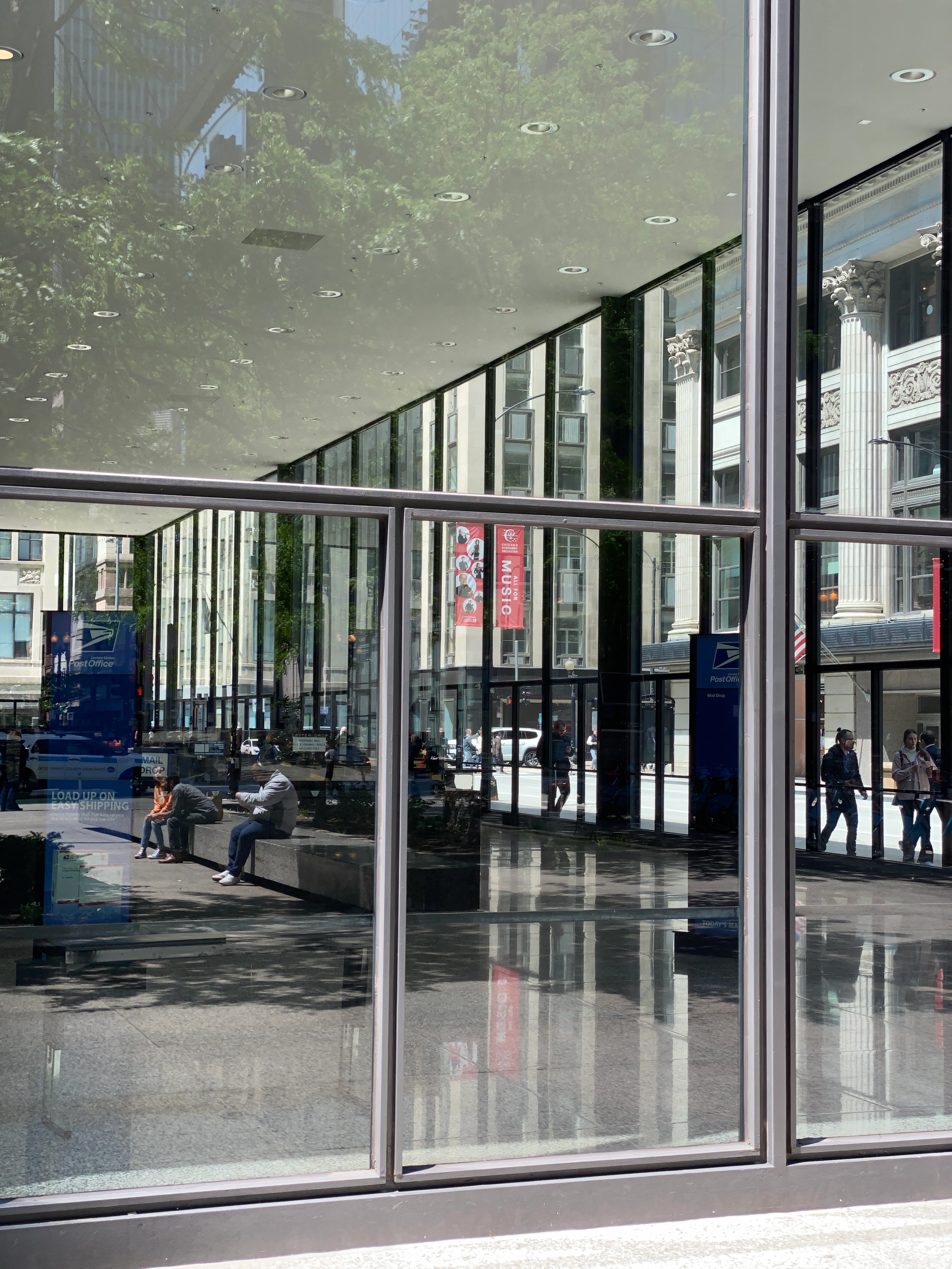 Floor-to-ceiling walls made of glass window cause interesting reflections and lots of light to stream into a very upscale post office.